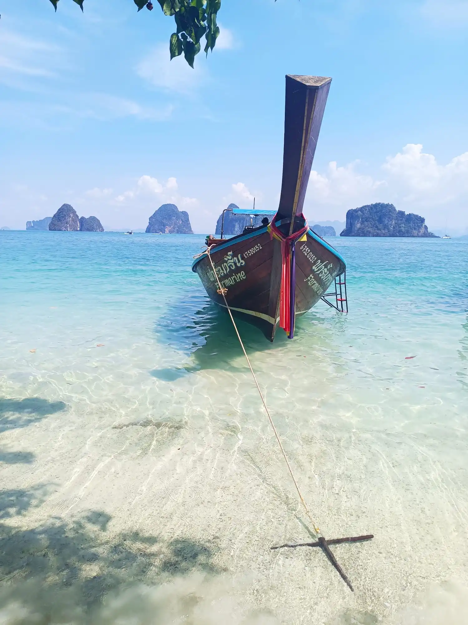 Longtail boat traditionnel naviguant dans les eaux turquoise de Krabi en Thaïlande